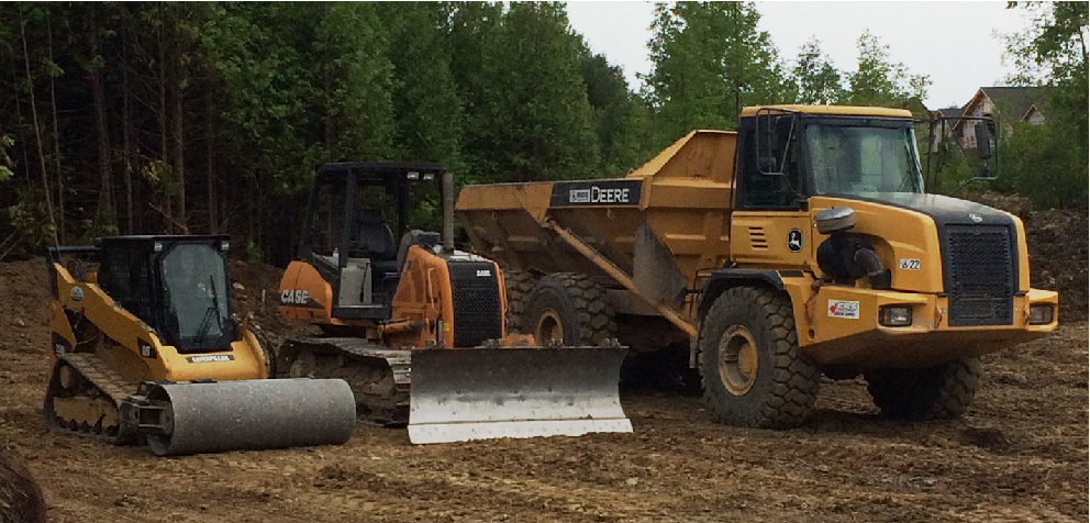 Skidsteer, excavator and dump truck parked on site